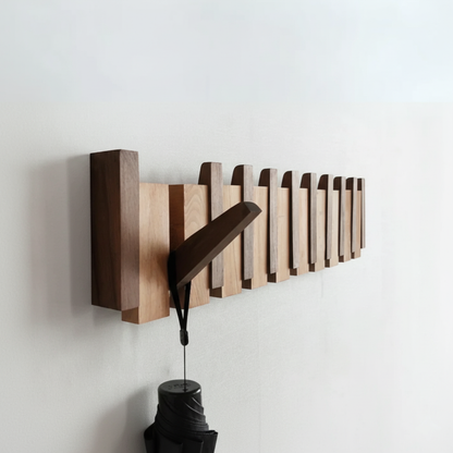 Holz-Garderobenleiste mit Klaviertasten-Design und hängendem Regenschirm