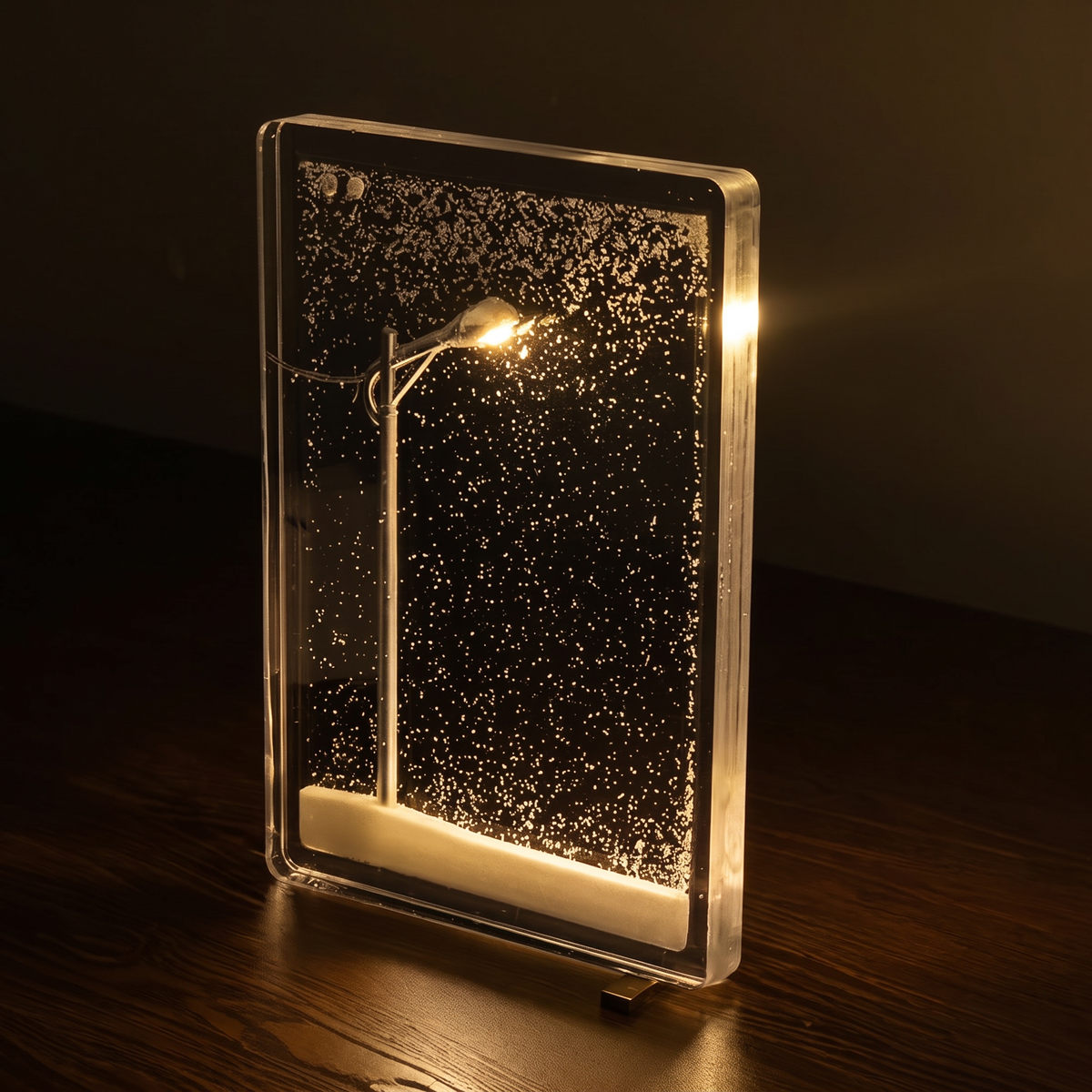 Schneefall-Lampe mit warmem Licht in Nahaufnahme auf dunklem Holz