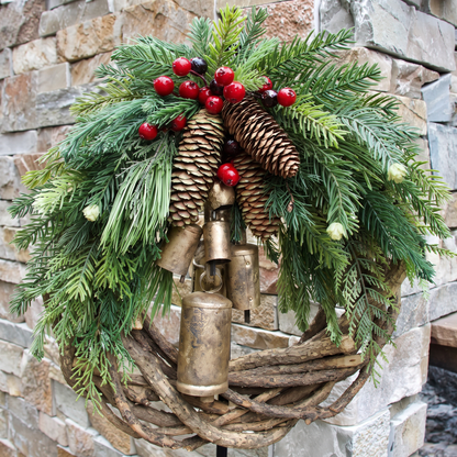 Detailansicht des Kranzes mit Kiefernzapfen, roten Beeren und goldenen Glöckchen