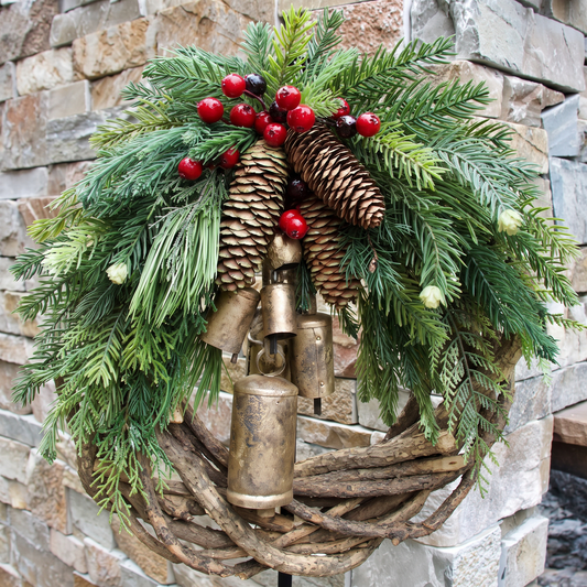 Detailansicht des Kranzes mit Kiefernzapfen, roten Beeren und goldenen Glöckchen